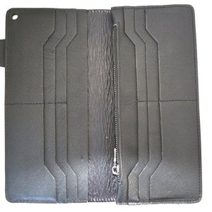 Puede incluir: Una cartera de cuero negro con m&uacute;ltiples ranuras para tarjetas y un compartimento con cremallera. La cartera tiene un cierre de solapa con un bot&oacute;n.