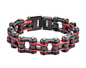 May include: A bracelet designed to look like a bicycle chain, with black and red links. The bracelet has a series of interconnected links in black and red, with silver-coloured rivets. The clasp is black and rectangular. This accessory is suitable for everyday wear.