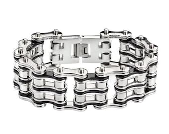 May include: A silver bracelet made of multiple rows of linked chains with black accents. The bracelet is made of metal and has a polished finish.