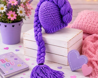 May include: A vibrant purple crocheted hat featuring a thick, long braided yarn extension that cascades down from the crown, ending in a full, loose tassel. The hat is crafted with a dense, textured stitch pattern in a solid, bright violet hue.