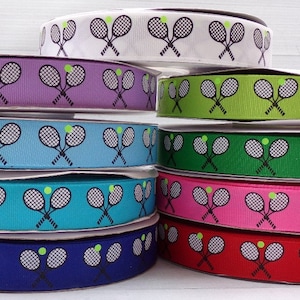 May include: A stack of ten spools of ribbon with a tennis racket and ball design. The ribbon colors are white, purple, green, blue, turquoise, pink, red, and navy blue.
