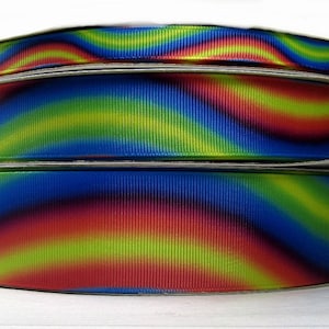 May include: Three rolls of colourful ribbon with a tie-dye pattern in shades of red, yellow, blue, and green.
