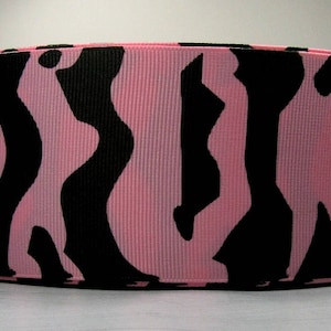 May include: Pink and black zebra print ribbon. The ribbon has a repeating pattern of black zebra stripes on a pink background.