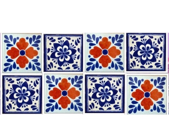 May include: Nine square ceramic tiles with a blue and white floral pattern and a red flower in the center of each tile.