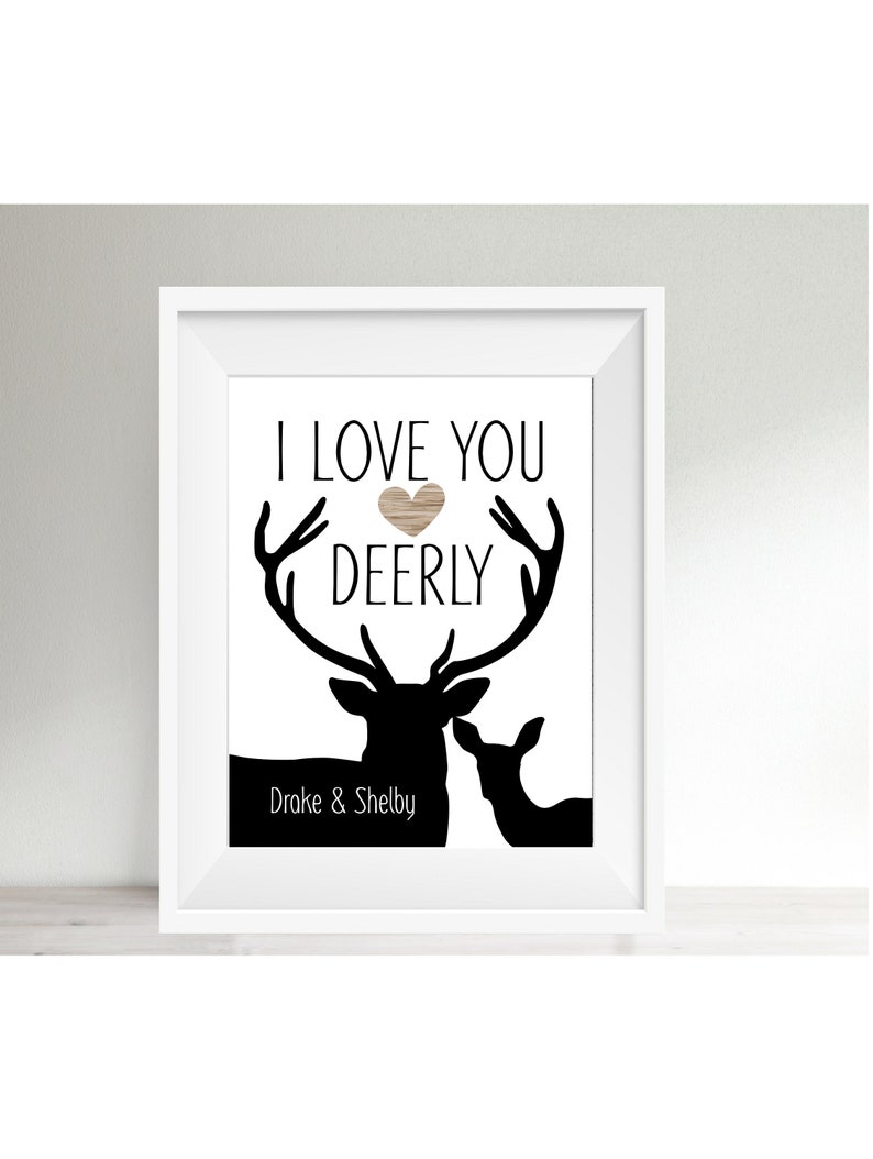 May include: A black and white print with the text "I love you deerly" and a heart shape. The print features a silhouette of two deer, one with antlers, and the text "Drake & Shelby" at the bottom.