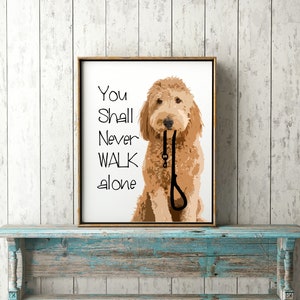 May include: A framed print with a white background featuring a brown dog with the text "You Shall Never Walk Alone" printed in black.