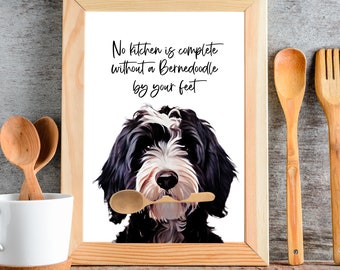 May include: A framed print with a black and white Bernedoodle dog holding a wooden spoon in its mouth. The print reads "No kitchen is complete without a Bernedoodle by your feet."