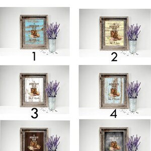 May include: A framed print with a rustic design, featuring a cowboy boot and floral accents. The text "PERFECT PAIR" is displayed above the boot, with names below. The image is accompanied by a metal bucket with lavender.