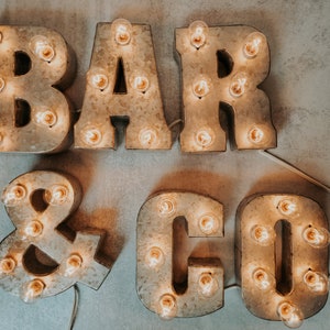 Letrero metálico con letras iluminadas de 18 cm y luces eléctricas pequeñas