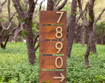 May include: A rusty metal sign with gold numbers 7, 8, 9, and 0. The sign has a directional arrow pointing to the right.