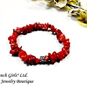 May include: Red coral chip bracelet with a silver bead accent. "French Girls" Ltd. Art & Jewelry Boutique.