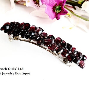 Peut inclure: Une pince à cheveux argentée ornée d'un groupe de pierres de grenat rouge foncé. "French Girls" Ltd. Art & Bijoux Boutique.