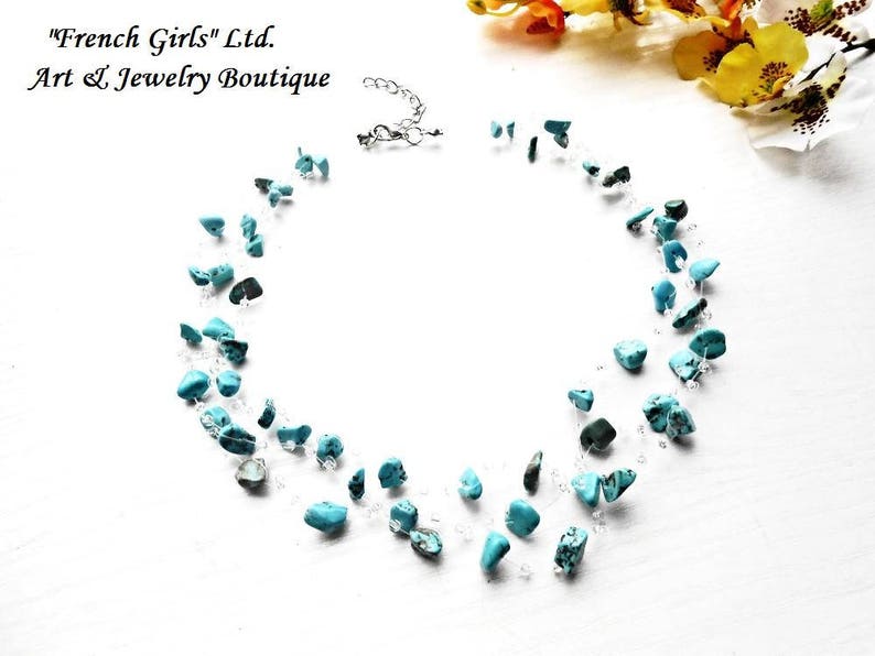 May include: Turquoise gemstone necklace with a silver chain. The necklace is made of small, irregular turquoise stones and silver beads.