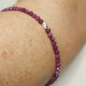 Può includere: Un braccialetto di pietre preziose rosa con un accento di perline d'argento. Il braccialetto è fatto di piccole perline rotonde ed è infilato su una sottile catena d'argento.