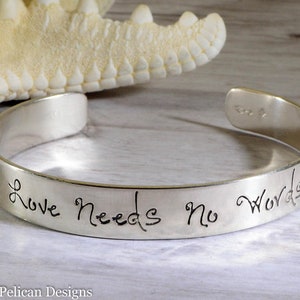 Op de afbeelding: Zilveren armband met de inscriptie "Love Needs No Words".