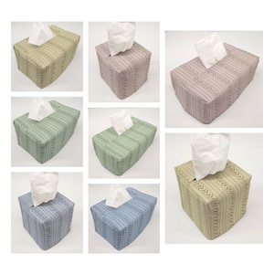 May include: Set of nine tissue box covers in various colors and patterns. The covers are made of fabric and have a rectangular shape. The covers are decorated with a striped pattern and a leaf design.