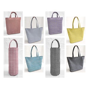 May include: Collection of eight gingham-patterned tote bags and bottle bags in various colors. The bags include red, light blue, purple, yellow, pink, teal, black and white, and dark gray. The tote bags have handles, and the bottle bags have a single handle.