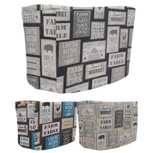 May include: Farm-themed decorative storage bins with a repeating pattern of rustic signs. The signs feature phrases like "Farm Table to Soul" and "Life is Better on the Farm," along with images of pigs and chickens. The bins are in shades of gray, white, and blue.