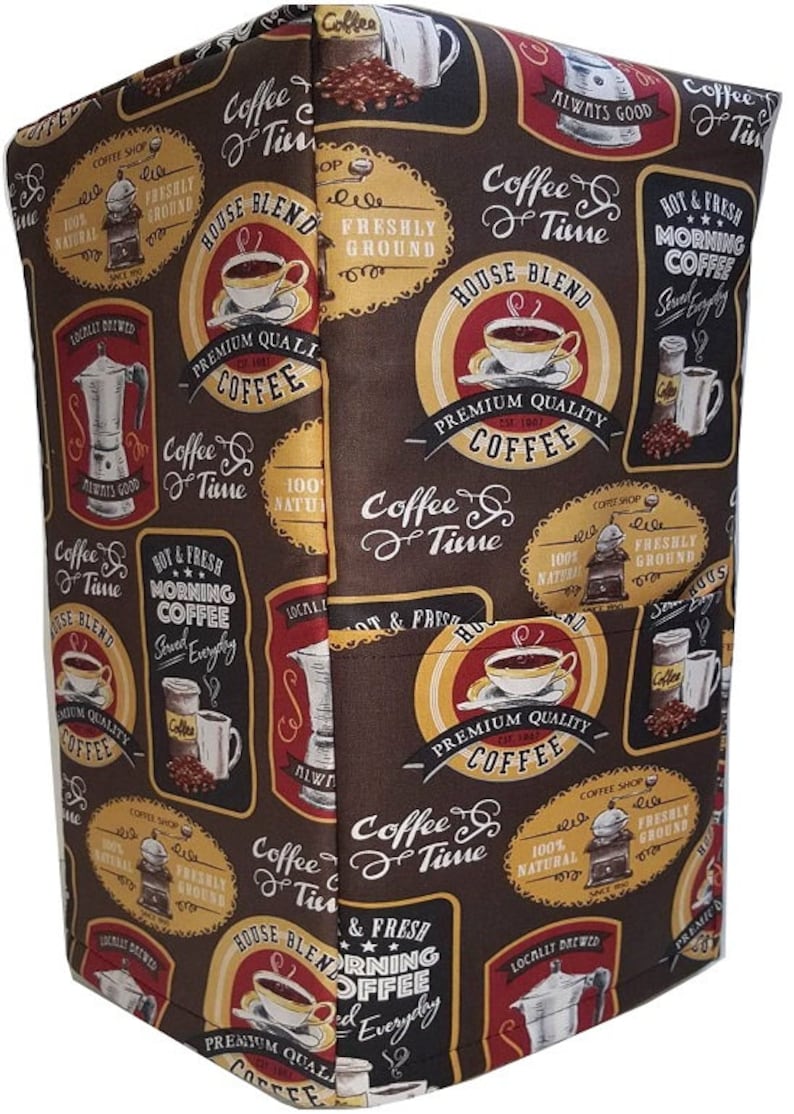 May include: A brown fabric with a repeating pattern of coffee-themed illustrations. The illustrations feature coffee cups, coffee beans, coffee grinders, and text that says "Coffee & Time", "House Blend", "Premium Quality Coffee", "Hot & Fresh Morning Coffee", and "100% Natural".