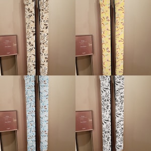 May include: Four pairs of refrigerator door handles with decorative fabric covers. The covers feature a repeating floral pattern in various colors, including brown, yellow, blue, and black.