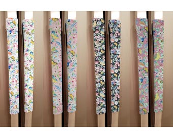 May include: Set of 10 colorful fabric drawer pulls with floral and bird patterns. The pulls are in various colors, including pink, blue, green, and yellow. The patterns feature delicate flowers and birds.
