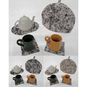 May include: Set of six floral print fabric coasters with a teapot and two mugs. The coasters are black and white with a floral pattern. The teapot is white and the mugs are green and yellow.