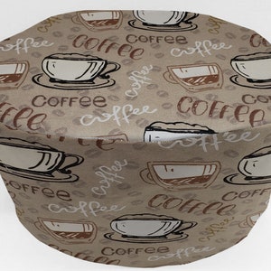 May include: A brown fabric coffee themed kitchen cover with a repeating pattern of coffee cups, coffee beans, and the word "coffee" written in cursive.