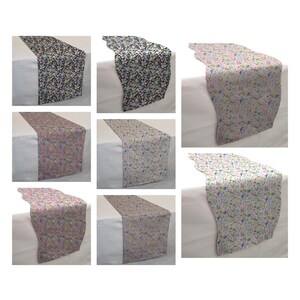 May include: A set of eight table runners with a floral pattern. The runners are available in three color combinations: black and white, pink and white, and blue and white.