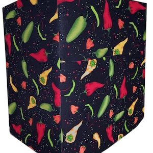 May include: Black appliance cover with a repeating pattern of red, green, and yellow chili peppers on a black background with white speckles.