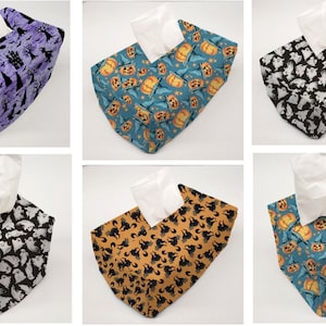 May include: Six different Halloween-themed tissue box covers. The covers feature various designs, including ghosts, pumpkins, and bats. The covers are made of fabric and have a square shape.