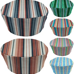 May include: A collection of six round, striped fabric covers in various color schemes. The covers feature vertical stripes in shades of blue, green, red, pink, and brown. The covers appear to be for a round object, such as a stool or ottoman.