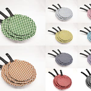 May include: Set of three nesting pan covers in various colors and checkered patterns. The covers are made of fabric and have black handles.