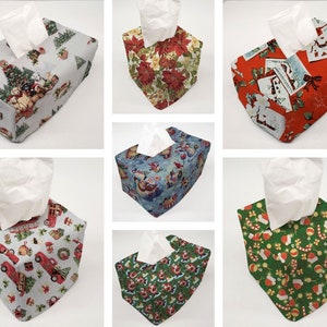May include: A set of 6 Christmas-themed tissue box covers. The covers are made of fabric and feature different holiday designs, including a snowman, a Christmas tree, and a Santa Claus. The covers are all square and have a white tissue box inside.