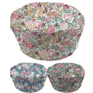 May include: Three round fabric chair cushions with floral patterns. The top cushion has a white background with pink, red, and yellow flowers. The bottom two cushions have a blue background with pink and white flowers.