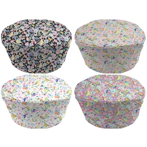 May include: Four round chair cushions with a floral pattern featuring birds and butterflies. The cushions are in four different color combinations: black and white, pink and white, white and blue, and pink and green.