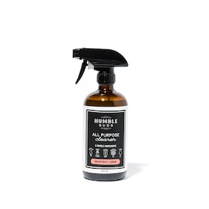 May include: A brown glass spray bottle with a black trigger sprayer. The label is white with black text that reads "Humble Suds All Purpose Cleaner 5 Humble Ingredients Grapefruit + Lemon 16 fl oz".