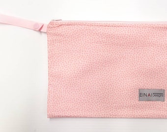 May include: A pink zippered pouch with a pink handle and a white label that says "EINAI Designs". The pouch has a small pink polka dot pattern.