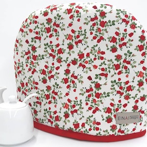 May include: White kettle cover with a red floral pattern. The cover has a red trim and the text "EINAI Designs" is printed on the bottom right corner.