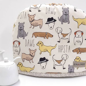 May include: A white cotton toaster cover with a pattern of dogs wearing hats, sunglasses, and bow ties. The text "DAWG" and "HIPSTA" is printed on the cover. The cover is made by EINAI Designs.