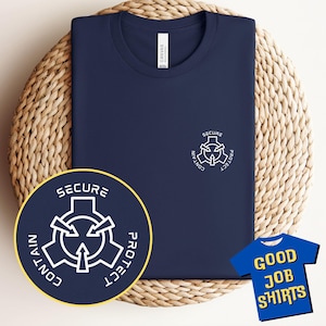 May include: A navy blue t-shirt featuring a white graphic of a symbol with the words "Secure, Contain, Protect" around it. The shirt is displayed on a woven wicker surface. A blue tag with the words "Good Job Shirts" is in the bottom right corner of the image.