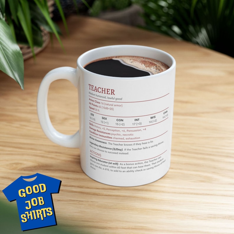 May include: White ceramic coffee mug with a black interior and a black coffee design. The mug has a black handle and features a printed design of a character sheet for a "Teacher" role-playing game character. The character sheet includes stats, skills, and abilities. The mug is sitting on a wooden surface.
