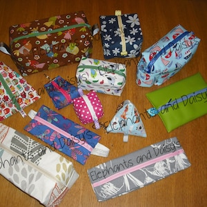 May include: A collection of 10 small zippered pouches in various colors and patterns. The pouches are made of fabric and leather. The pouches are all different sizes and shapes. The pouches are labeled "Elephants and Daisy's".