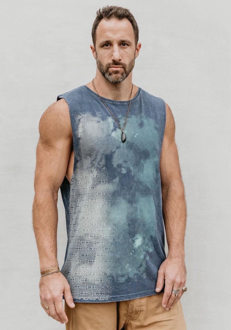 May include: A sleeveless blue and white tie-dye tank top with a geometric pattern on the left side. The tank top is made of a soft, comfortable fabric and has a relaxed fit.