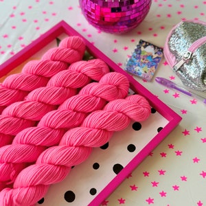 May include: Pink yarn in a pink and white polka dot tray with a black and white polka dot pattern. The tray is on a white background with pink stars.