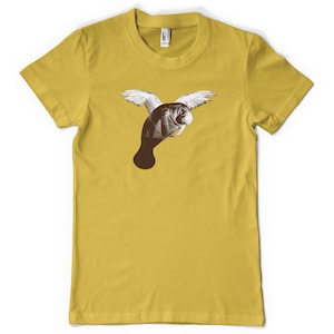 Könnte beinhalten: Ein gelbes T-Shirt mit einem Aufdruck eines Seekuhs mit Flügeln. Die Seekuh ist braun mit weißen Flügeln.