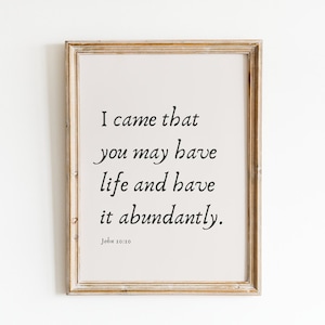 May include: A framed print with a beige background and black text that reads "I came that you may have life and have it abundantly. John 10:10".