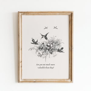 May include: A framed black and white botanical print featuring a floral arrangement with birds in flight. The print includes the text: "Are you not much more valuable than they?" The frame is a light brown color.