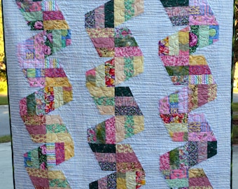 Quilt with Scrappy Pink, Green and Blue Twisted Ribbons on Light Blue/Grey Background