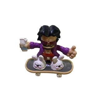 Puede incluir: Una figura vestida de morado con gafas de sol y bigote monta un monopatín con ruedas en forma de conejo. La figura sostiene un pequeño objeto blanco en su mano izquierda.