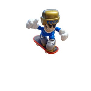 May include: A blue and gold fingerboard toy with a figure wearing a helmet with the word "CCCP" on it. The figure is performing a trick on a red and black skateboard.